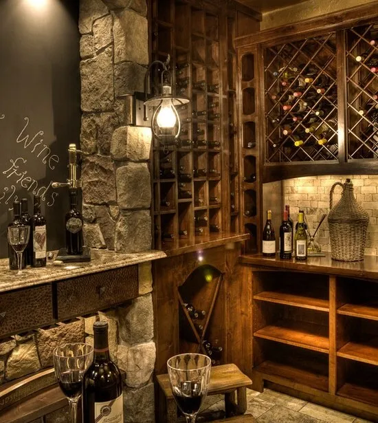 Perete de piatră și rafturi de lemn cu sticle de vin într-o pivniță