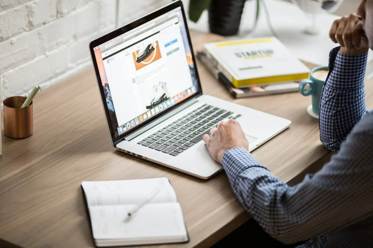 Laptop pe birou, cu un site web deschis